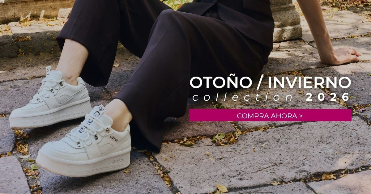 Modelo luciendo tenis plataforma blancos Gotta de la colección Otoño/Invierno 2026, combinados con un traje negro en un entorno urbano. Encuentra botas, botines, zapatos, sandalias y tenis para mujer.