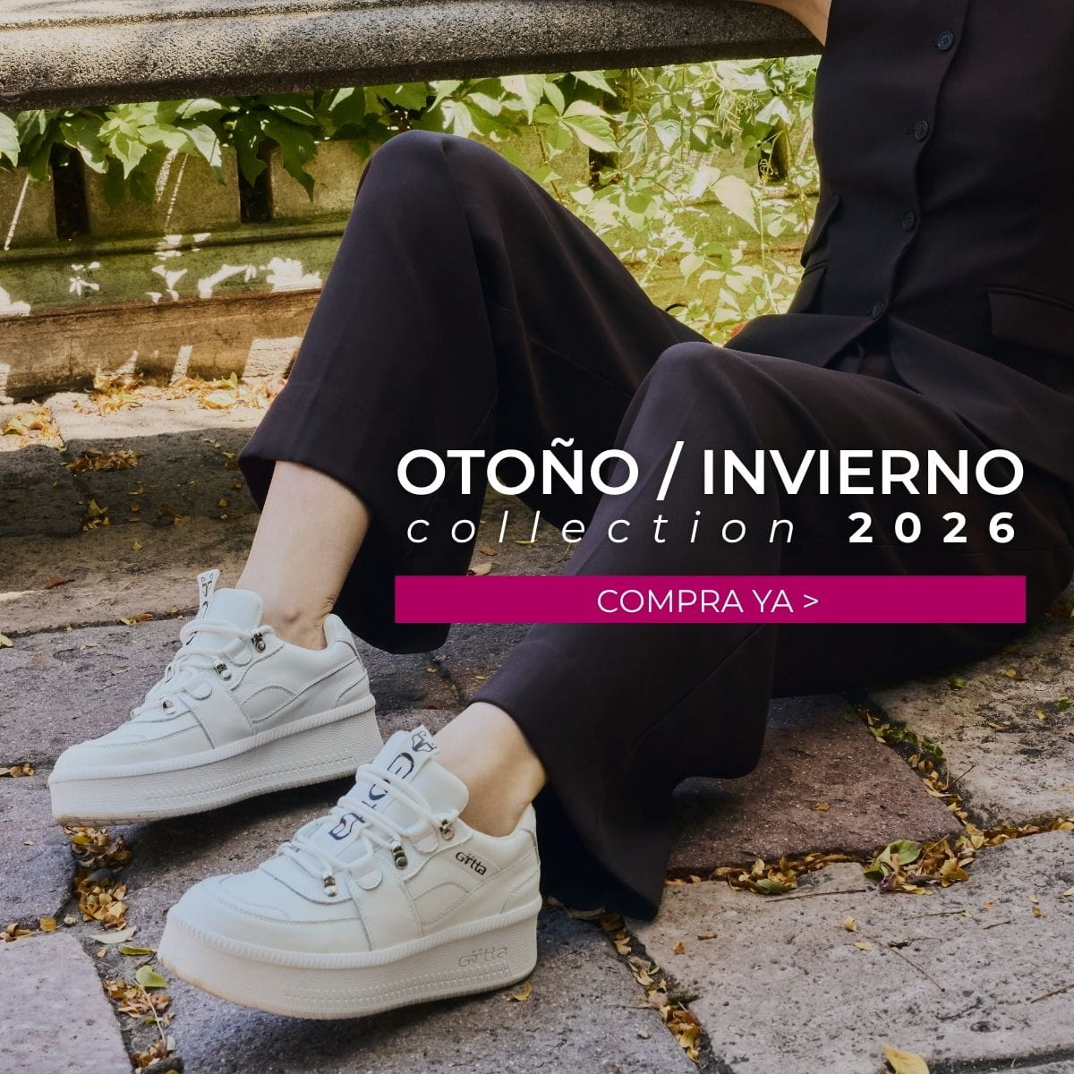 Modelo luciendo tenis plataforma blancos Gotta de la colección Otoño/Invierno 2026, combinados con un traje negro en un entorno urbano. Encuentra botas, botines, zapatos, sandalias y tenis para mujer.